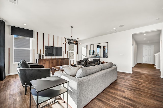 living room with dark hardwood / wood-style flooring and a notable chandelier