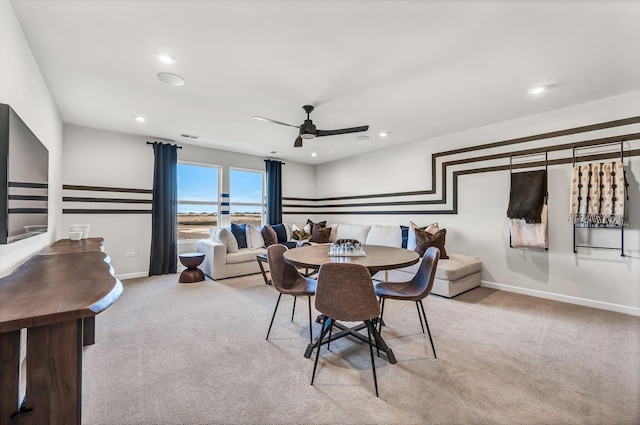 dining area featuring light colored carpet and ceiling fan