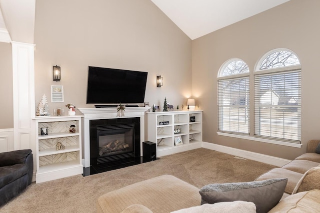 carpeted living room with high vaulted ceiling and ornate columns