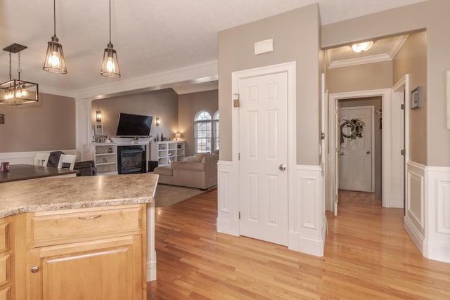 kitchen with pendant lighting, crown molding, light hardwood / wood-style flooring, and light brown cabinets