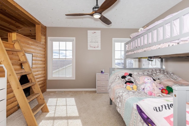 bedroom with ceiling fan, rustic walls, and light carpet