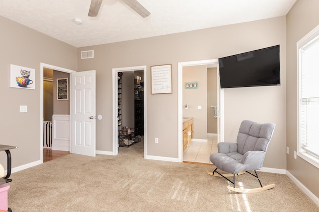 sitting room with light colored carpet and ceiling fan