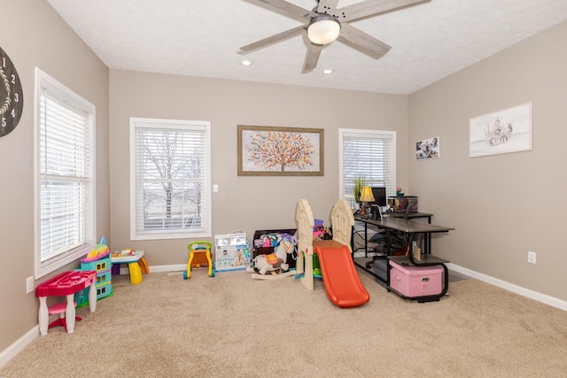 game room with a textured ceiling, ceiling fan, and carpet