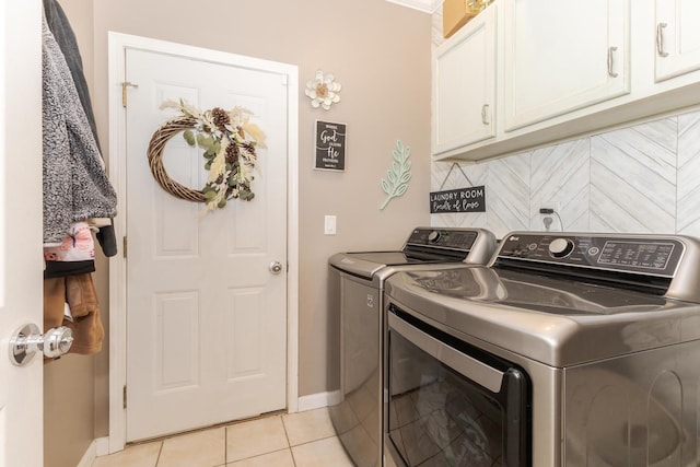 laundry room with cabinets, light tile patterned floors, and washing machine and clothes dryer