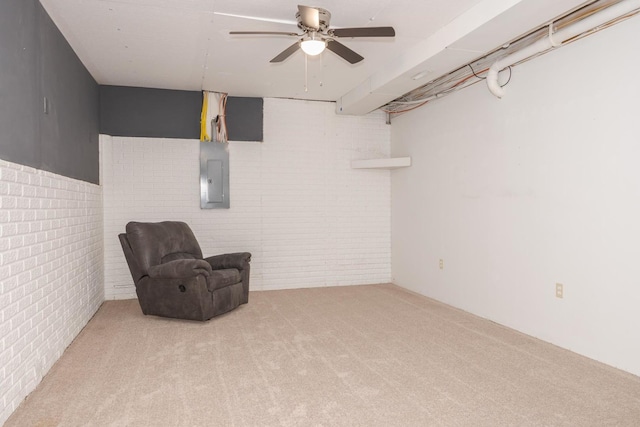 sitting room featuring brick wall, light colored carpet, electric panel, and ceiling fan