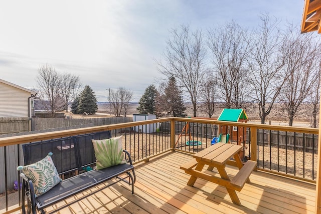 deck with a storage shed and a playground