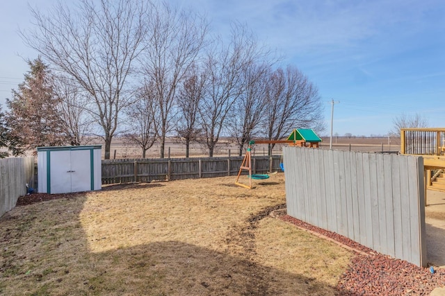 view of yard with a storage shed and a playground