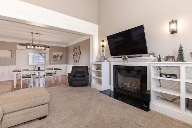 living room with crown molding, carpet flooring, and a notable chandelier