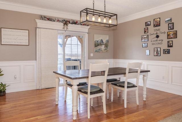 dining room with light hardwood / wood-style flooring and ornamental molding