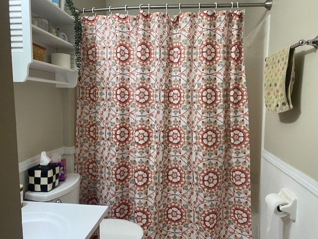 bathroom featuring a shower with curtain, vanity, and toilet