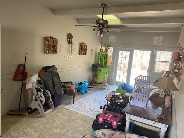 living room featuring ceiling fan and beam ceiling