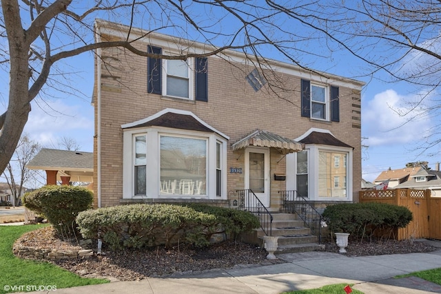 view of front of property featuring fence and brick siding