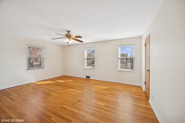 empty room with light wood-type flooring, baseboards, visible vents, and a ceiling fan