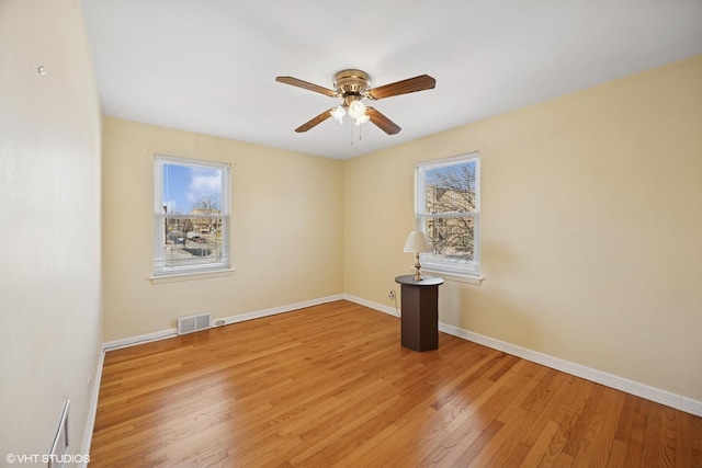 empty room with ceiling fan, baseboards, visible vents, and light wood-type flooring