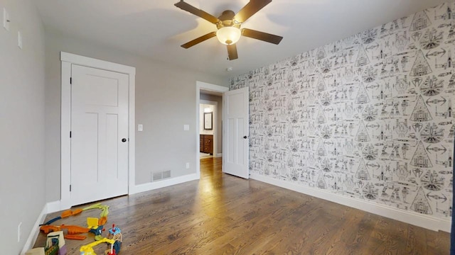 unfurnished bedroom with dark hardwood / wood-style flooring and ceiling fan