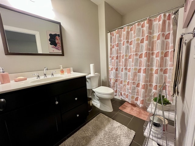 bathroom featuring tile patterned floors, vanity, toilet, and walk in shower