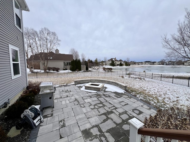 snow covered patio with a fire pit