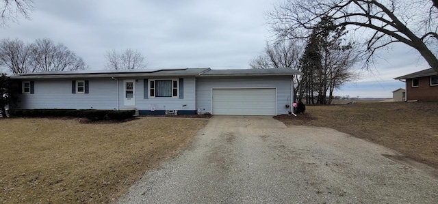 ranch-style home with a garage and a front lawn