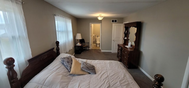 bedroom with dark colored carpet and ensuite bathroom