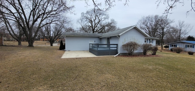 back of property featuring a lawn, a patio, and a deck