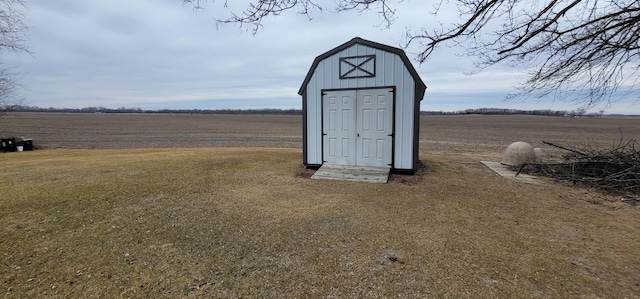 view of outdoor structure with a yard and a rural view