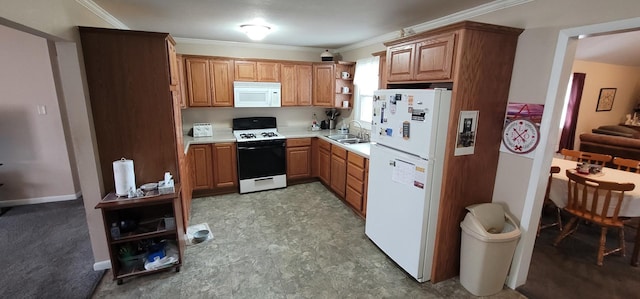 kitchen with crown molding, white appliances, and sink