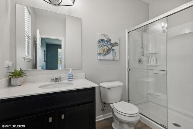 bathroom with vanity, wood-type flooring, a shower with door, and toilet