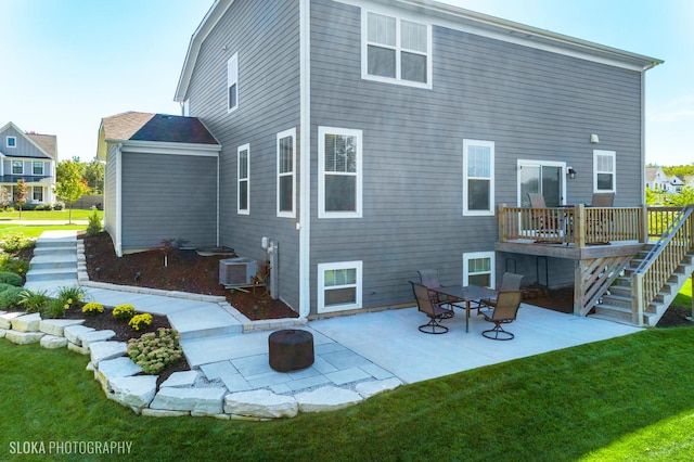 rear view of house with central AC unit, a lawn, a patio, and a wooden deck