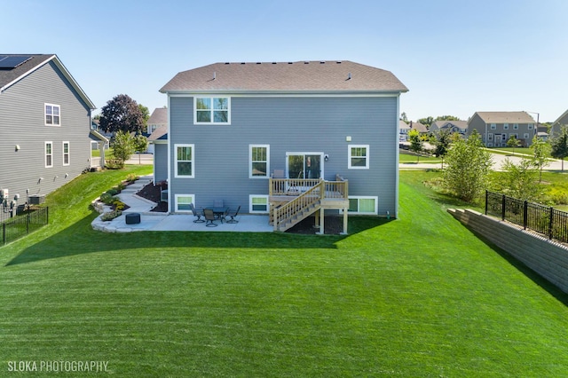 back of property featuring a wooden deck, a patio, central air condition unit, and a lawn