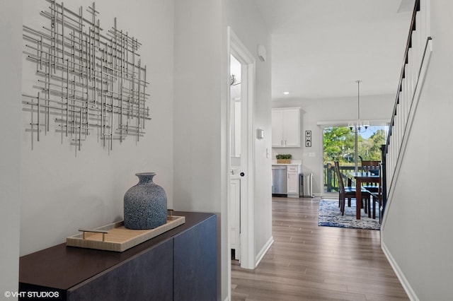 corridor featuring an inviting chandelier and dark hardwood / wood-style flooring