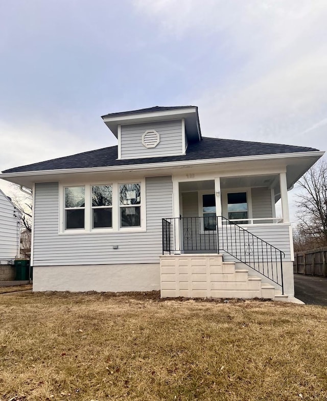 bungalow-style house with covered porch and a front lawn