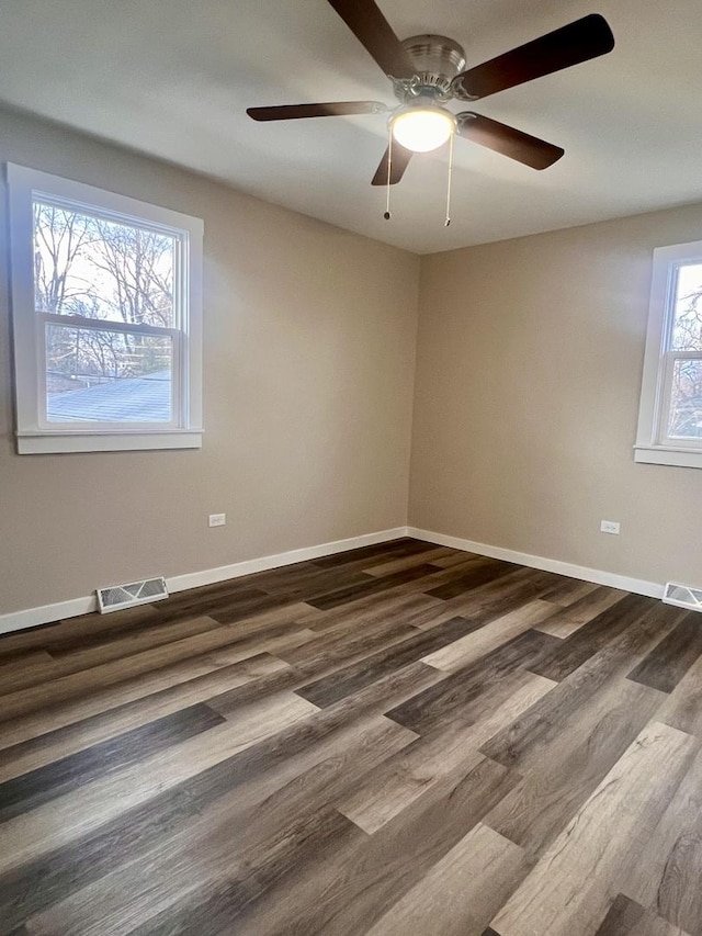 empty room featuring dark wood-type flooring and ceiling fan