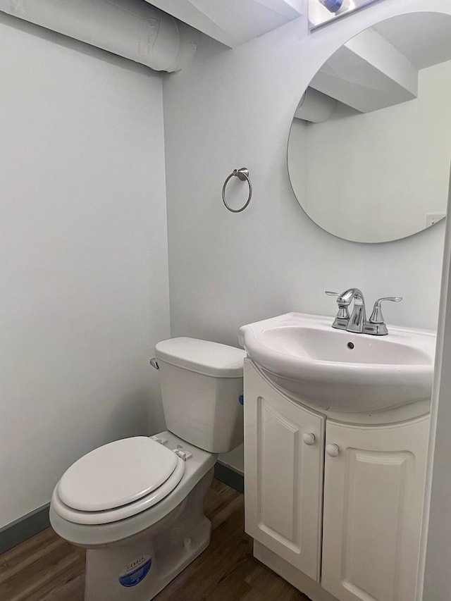 bathroom with hardwood / wood-style flooring, vanity, and toilet