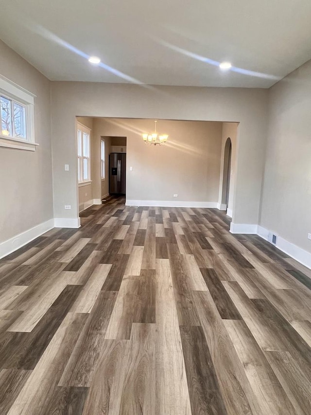 unfurnished living room with dark hardwood / wood-style floors and a chandelier