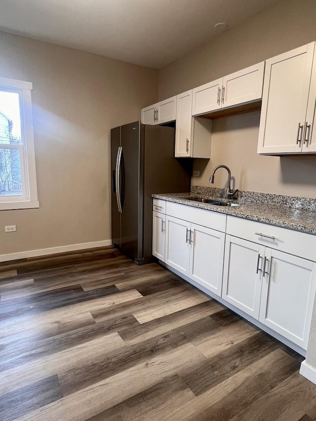 kitchen with white cabinetry, sink, dark hardwood / wood-style flooring, stainless steel refrigerator with ice dispenser, and light stone countertops