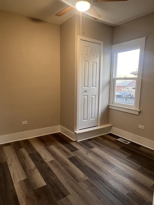 unfurnished bedroom featuring dark wood-type flooring and ceiling fan