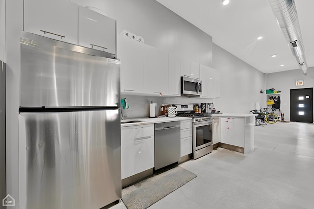 kitchen with decorative backsplash, stainless steel appliances, white cabinets, and a high ceiling