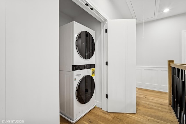 washroom featuring hardwood / wood-style floors and stacked washer and clothes dryer