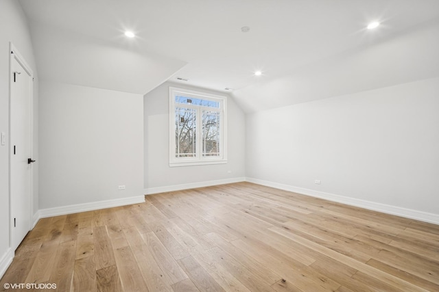 bonus room with vaulted ceiling and light wood-type flooring