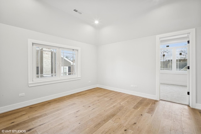 empty room with lofted ceiling and light hardwood / wood-style flooring