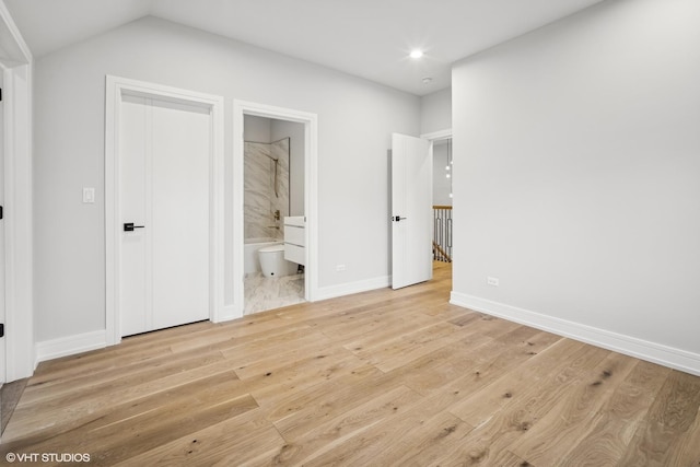 unfurnished bedroom with ensuite bathroom and light wood-type flooring