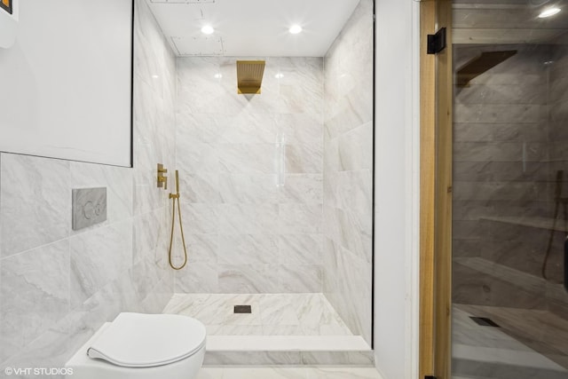 bathroom featuring a tile shower, tile walls, and toilet