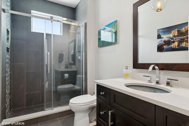 bathroom featuring vanity, toilet, and a shower stall