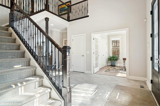 entrance foyer featuring a towering ceiling and baseboards