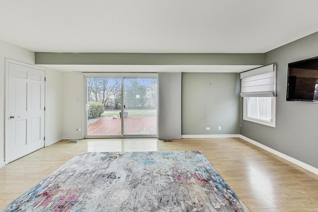 unfurnished room featuring a healthy amount of sunlight and light wood-type flooring