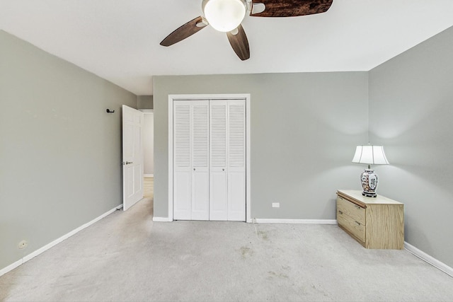 unfurnished bedroom featuring ceiling fan, light carpet, and a closet