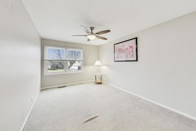 spare room featuring light colored carpet and ceiling fan