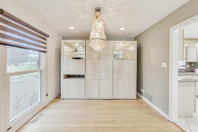 interior space with an inviting chandelier and light wood-type flooring