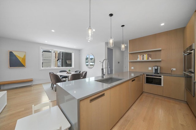 1834 N Rockwell St Unit 1R, Chicago, IL 60647 - kitchen with a sink, modern cabinets, light wood-type flooring, hanging light fixtures, and double oven