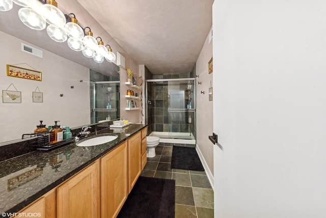 bathroom with vanity, tile patterned flooring, toilet, and walk in shower